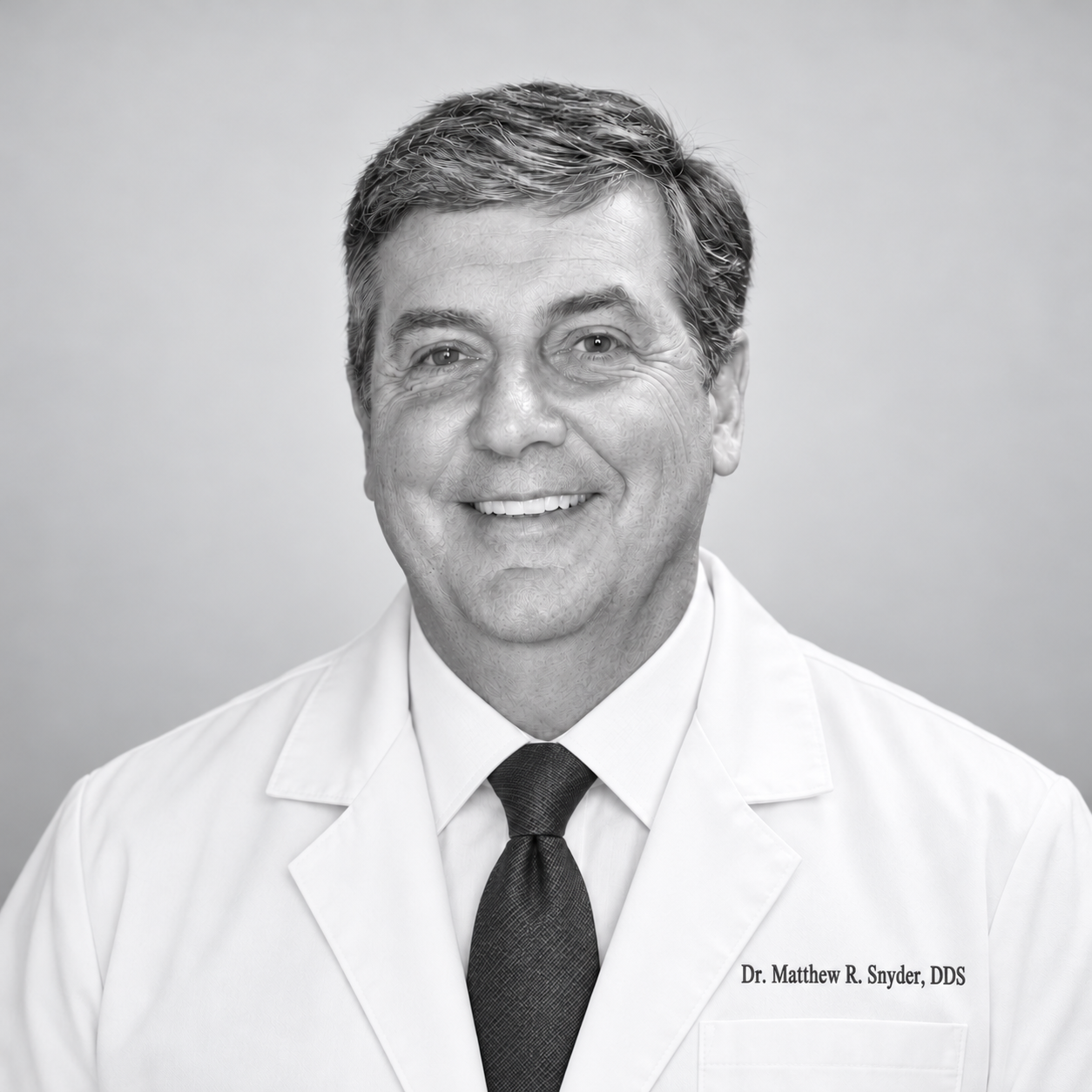 Dr. Matthew R. Snyder smiling in a white dental coat